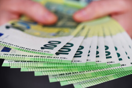 Bargeld, zwei H&auml;nde halten 100 Euro Banknoten.