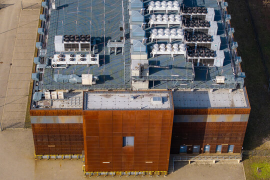 Aerial view of a modern data center building, showing multiple hvac and cooling units on its roof and rusty facade, Warsaw, Masovian Voivodeship, Poland.