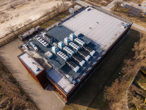 Aerial view of data center building with numerous air conditioning and ventilation systems on roof for server cooling, Warsaw, Masovian Voivodeship, Poland.