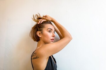 Obraz premium Woman adjusting short hair indoors.