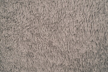 A close up shows the uniform grey color and soft, fluffy texture of a fabric surface. © vannet
