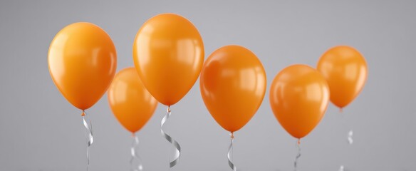 Obraz premium Bright orange balloons with silver ribbons perfect for festive party decor and joyful events.