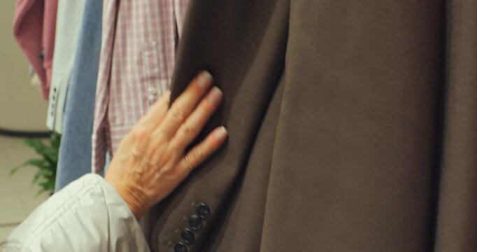Shopper Running Her Hand Over Clothing Displayed On Rails