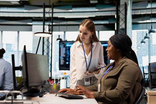 Friendly IT expert teaching intern to use artificial intelligence. Jolly manager guiding junior dev through AI tool integration, mentoring her on using machine learning APIs