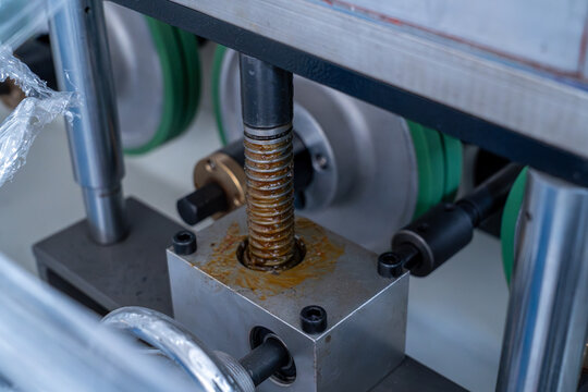 Industrial lead screw mechanism with lubricant in a production machine.