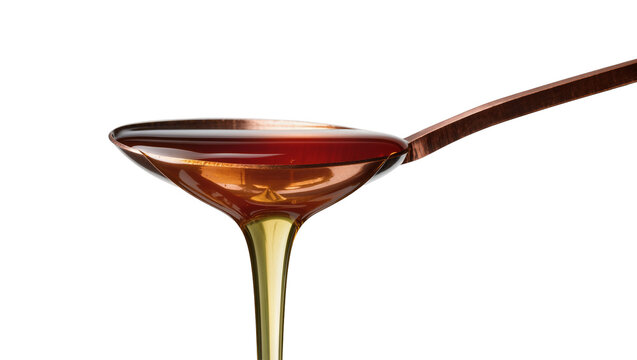 Isolated view of golden liquid dripping from spoon, liquid on spoon and pouring down