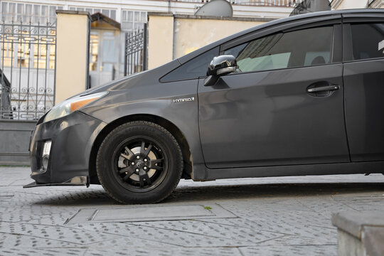Tbilisi, Georgia - March 08, 2026: Grey gray metallic color colour Toyota Prius Hybrid being charged on a public parking lot. Nobody in the vehicle. Side view