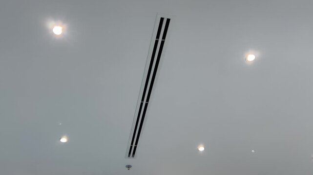 Abstract background of modern office ceiling. Minimalist architecture with black linear vent and smooth recessed light