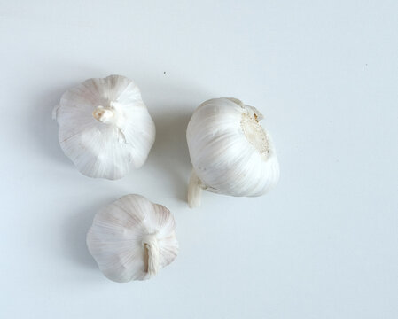 three heads of garlic on a white background