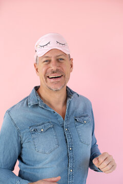 man with pink sleep mask in front of pink background
