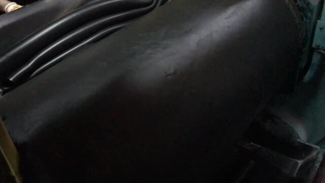 Industrial Rubber Compounding Process: Close-Up of Raw Rubber Mixture on Metal Roller Mill