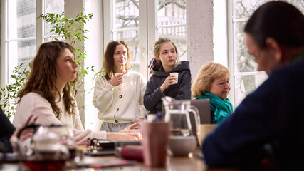 Women listening with interest during creative office meeting. Concept of attentive teamwork...