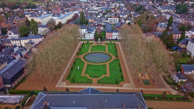 Saint-Pierre Cathedral and the formal Bishop's Garden, overlooking the city of Lisieux in Normandy, France. Aerial backward tilt-up reveal