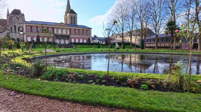 Garden of Bishop with its pond and historic buildings in Lisieux, Normandy, France. Panning