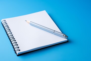 Fototapeta premium Blank spiral notebook with a pencil lying on its pages, ready for writing