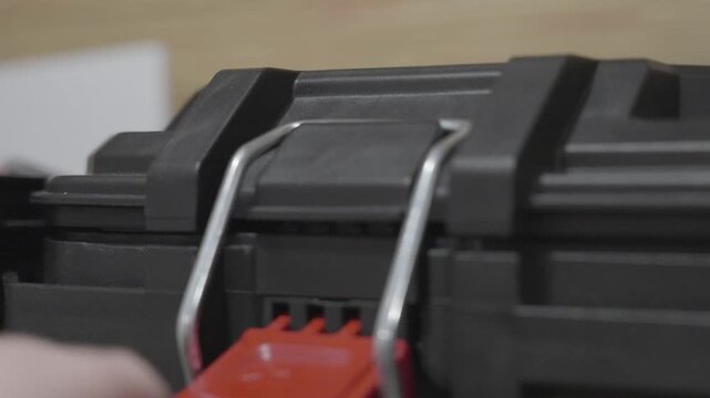 A man placing the metal latch bar of a hinge onto the lock.