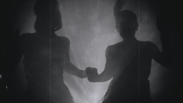 old film 1920s style black and white color, shadow silhouette two woman dancing in night club. Sexy girls friends together flapper female have fun at dance floor retro party new year roaring twenties.