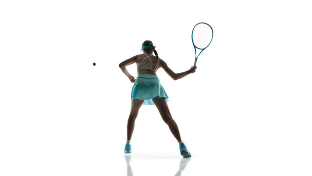 Female tennis player mid air movement during intense play isolated on white. Concept of high intensity training, athletic performance focus, strength and control, game day energy.