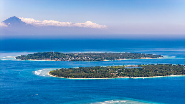 Aerial view of Gili islands with Mount Agung volcano in the distance, Indonesia