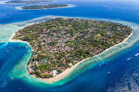 Aerial view of Gili Air island in Indonesia featuring beaches, reefs, and local village
