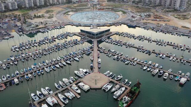 Aerial view of the marina filled with boats, contrasted against the backdrop of city buildings in the distance, Ashdod, South District, Israel.