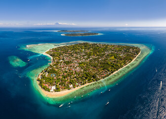 Breathtaking aerial shot of a tropical island surrounded by clear blue water and reefs © whitcomberd