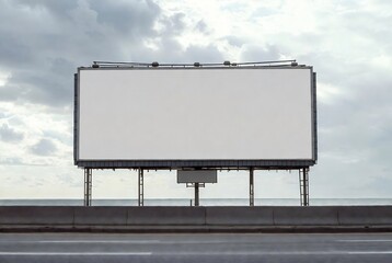 Obraz premium A billboard stands on a highway under a cloudy sky.
