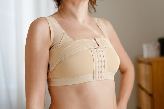 A close-up of a woman after mammoplasty wearing a support bra and post-operative corset. Post-surgery rehabilitation, support for women after breast cancer.