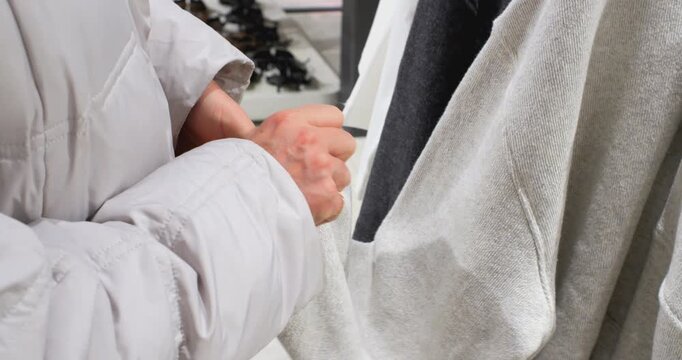 Feeling clothes on hangers before purchasing