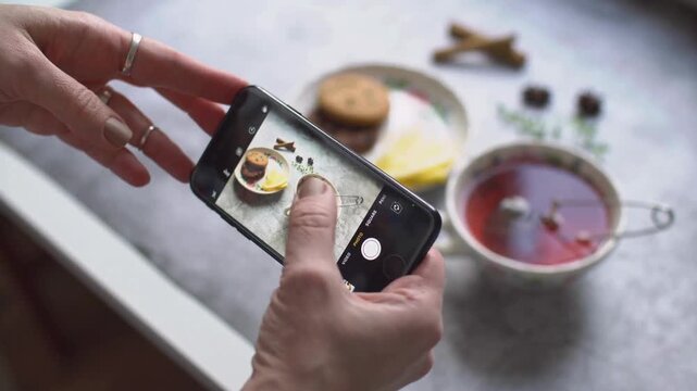 Woman Photographing Cup of Tea &ndash; Female Blogger Capturing 4K Video for Social Media Post