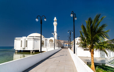 Exterior view of the Al Rahma Floating Mosque on the Red Sea coast in Jeddah, Saudi Arabia, during a bright sunny day © Leonid Andronov