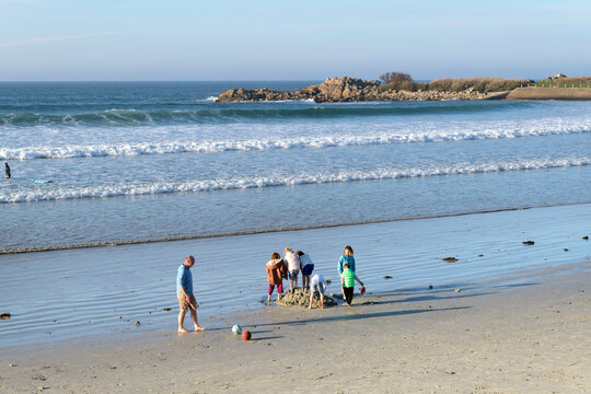 Une famille avec des enfants qui jouent sur une plage en Bretagne