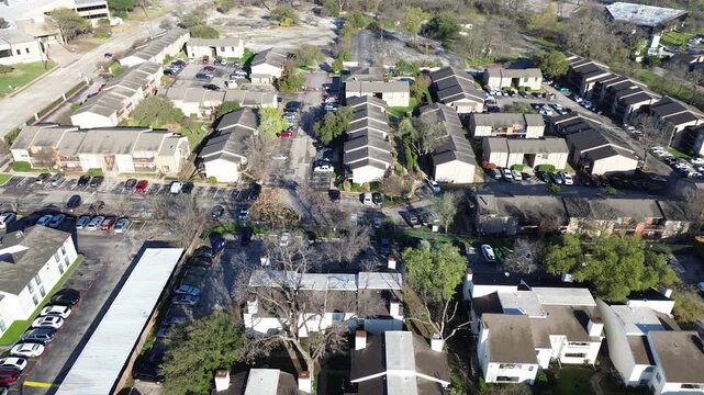 Apartment row layout near Fair Oaks Ave, Walnut Hill Ln shows long residential blocks corridor with parking courts and open land nearby. Dark roofs, bare trees, cool seasonal tones, midtown Dallas
