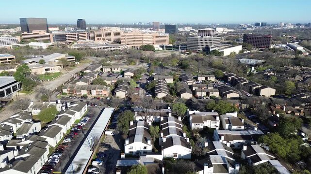 Fair Oaks Ave apartments corridor leading toward Greenville Ave midrise offices. Mixed roofing patterns, sparse winter trees, balanced shadows define neighborhood textures in midtown Dallas, TX