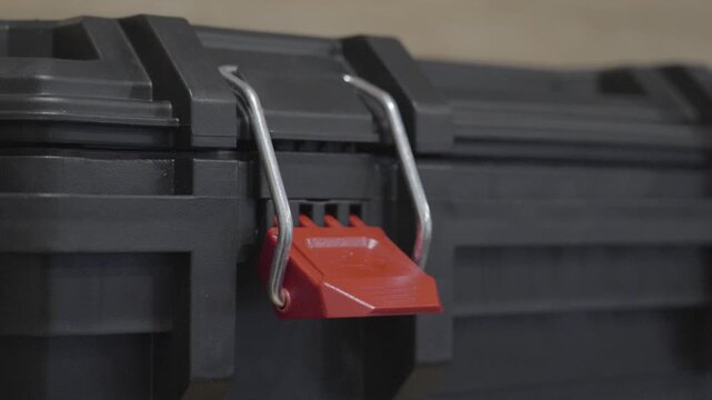 Handheld clip of a toolbox hinge unlocked but not open.