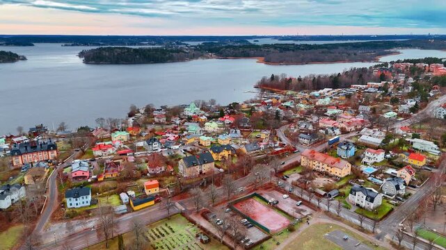 Urban scenery of Vaxholm with lovely houses. Peaceful grey waterscape with islets under the cloudy sky in the backdrop. Aerial view.