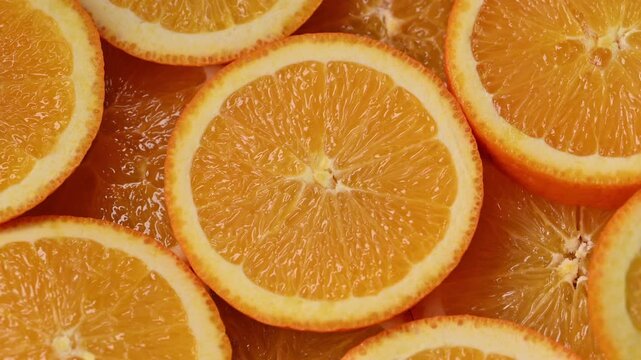 Top view of fresh orange slices forming vibrant citrus pattern. Juicy tropical fruit texture with slow camera movement, bright summer background for healthy food, drink refreshment fruit