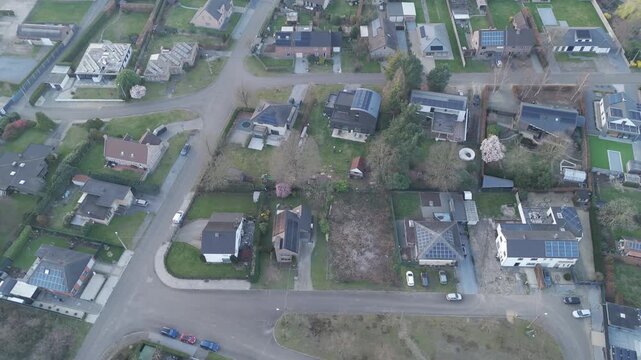 Aerial, strafe right, rightward slide Drone flight of Suburban Neighborhood with houses, gardens and streets. Urban planning, renewable energy. Solar panels. Rozendaal neighborhood in Diepenbeek, Belg