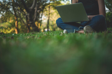 Close up businesswoman hand typing laptop drink black coffee cup in green garden cafe. Woman Hands love drinking hot coffee working from home. Business women with black coffee or hot chocolate cafe