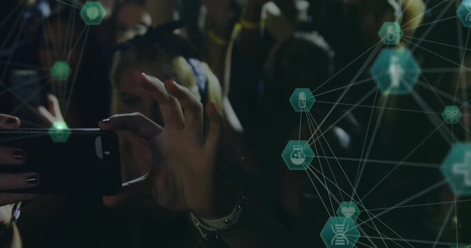 Animation of connections of hexagons with icons over hands of diverse people on concert