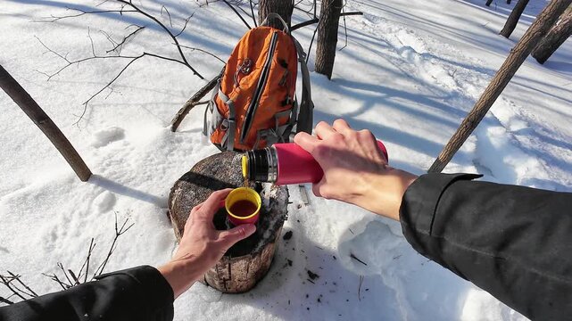 Warm Beverage Pause. Cold Forest Scene With Hot Drink. Individual Pauses For Warmth In Snowy Wilderness Setting. Person Refuels With Hot Liquid Beside Snowcovered Stump In Forest Environment