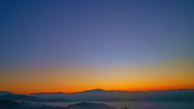 Time lapse beautiful sunrise above the mist in the valley.
There is a sweet sky on the horizon caused by the radiant light of the sun.
colorful sky of sunrise