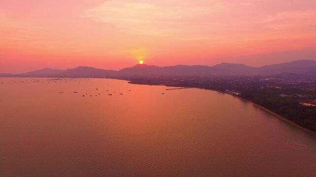 Above the mountain range, a sweet and serene sunset sky unfolds clouds tinged with rose and lavender hues, glowing softly as daylight gives way to the tender calm of evening.