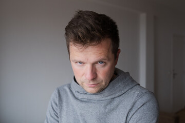 Fototapeta premium Mid Shot Emotional Portrait of a Middle Aged Man Looking Reproachfully at the Camera