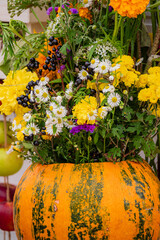 Obraz premium Bright sunflower arrangement in a vibrant pumpkin vase celebrating autumn's beauty