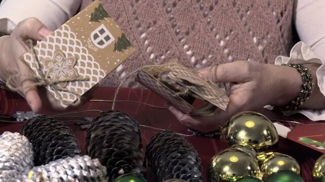 Woman's hands crafting a house shaped Christmas gift box