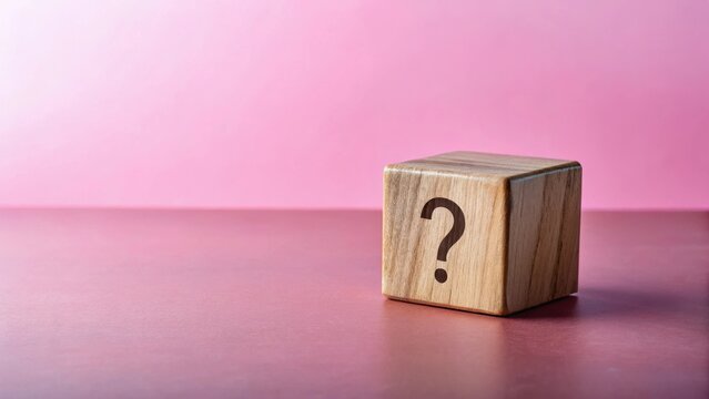 A solitary wooden cube rests on a smooth surface, its single face displaying a question mark, posing an enigma against a soft, rosy backdrop.