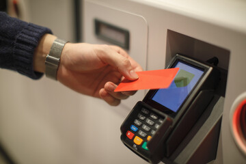 Hand paying with card at payment terminal in self service machine. Contactless transaction, banking and modern payment technology concept.