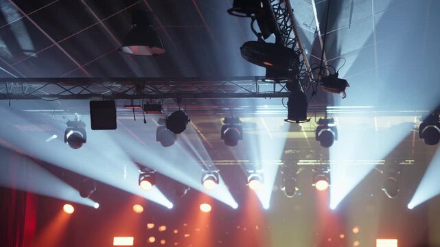 Dynamic stage lighting rig with powerful white and orange beams cutting through atmospheric haze, creating a dramatic effect for concerts, shows, or corporate events