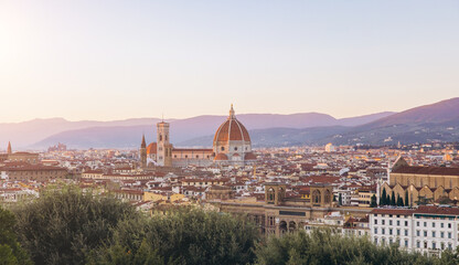 Fototapeta premium Florence cityscape featuring Cattedrale di Santa Maria del Fiore and Brunelleschi's Dome glowing at sunset, with Tuscan hills
